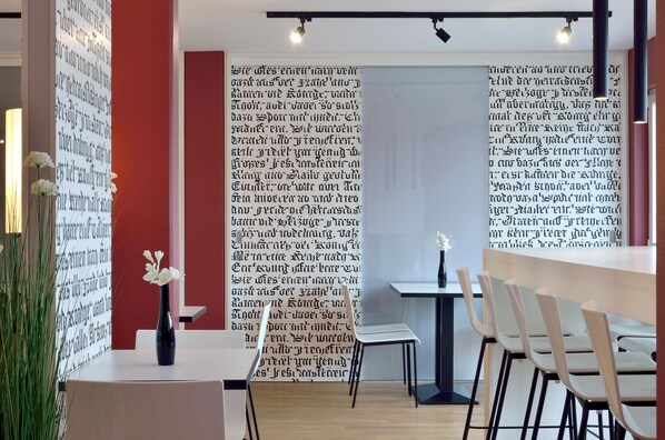 Un interno moderno con un tavolo bianco, sedie e un vaso con fiori bianchi.