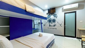 A modern hotel room with bunk beds, a flat-screen TV, an air conditioning unit, and a wall decal. - The Secret Service Hotel (Bangkok)