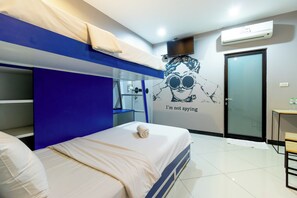 A modern hotel room with bunk beds, a flat-screen TV, an air conditioning unit, and a wall decal. - The Secret Service Hotel (Bangkok)