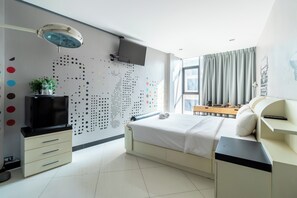 A modern hotel room with a bed, a desk, a TV, and a wall with a dot pattern. - The Secret Service Hotel (Bangkok)