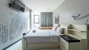 A modern bedroom with a bed, bedside tables, a TV, and a window with curtains. - The Secret Service Hotel (Bangkok)