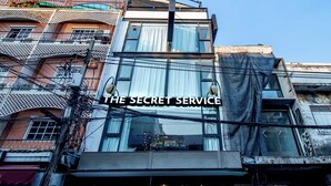 A multi-story building with a sign reading "THE SECRET SERVICE". - The Secret Service Hotel (Bangkok)