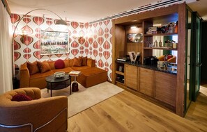 Un salon confortable avec un canapé, une table basse et une petite table d’appoint. Il y a également un coin cuisine avec des meubles en bois et un plan de travail.
