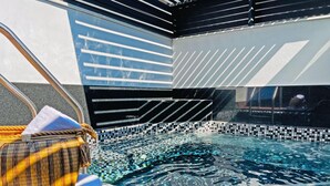 A modern indoor pool with mosaic tile flooring and a clear view of the pool area. - Boutique Hotel Cadillac (Mexico City)