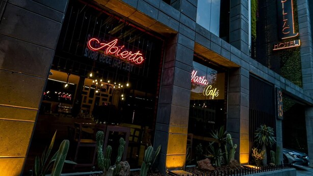 A building with a neon sign reading "Abierto" and "Narta Café". - Boutique Hotel Cadillac (Mexico City)