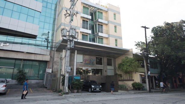 Un edificio de varios pisos con un cartel que dice 'Taste' en la planta baja.