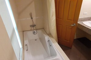 Une salle de bain avec une baignoire, une douche et un lavabo.