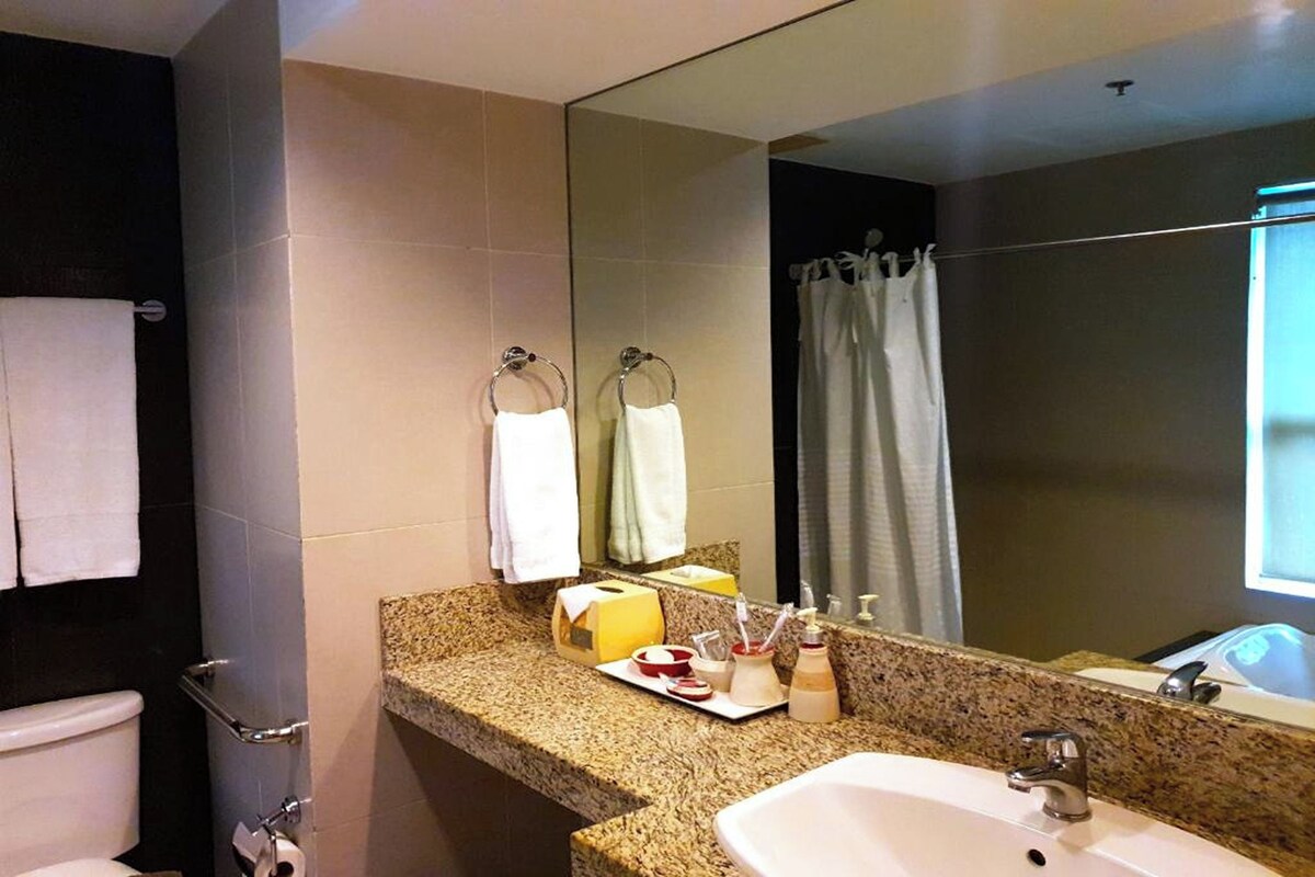 A bathroom with a sink, mirror, towel rack, and shower curtain.