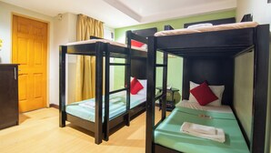A room with bunk beds, a wooden door, a small table, and a green wall. - Festive Hotel Makati (Makati)