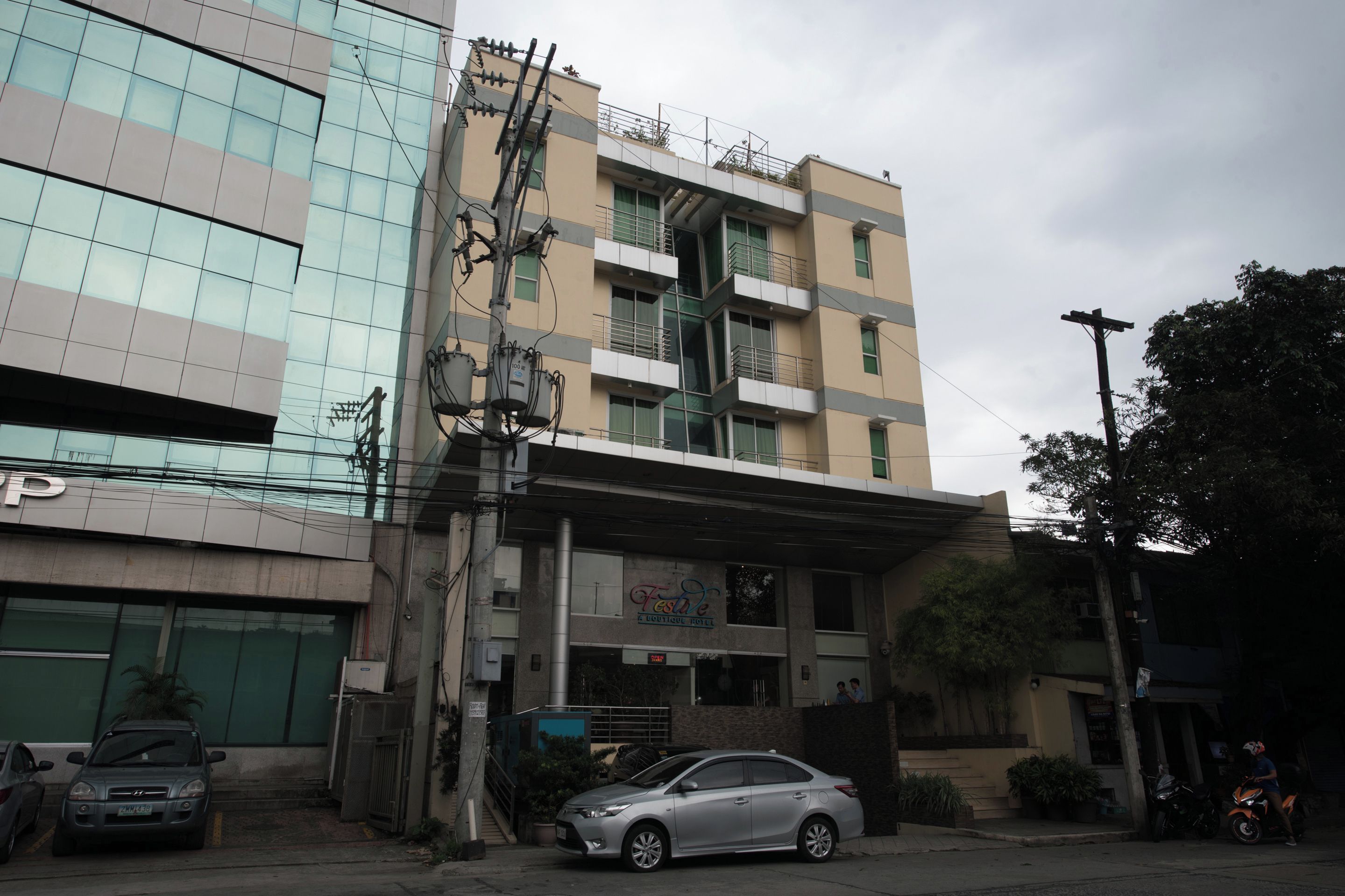 A multi-story building with a ground-level commercial space, a visible staircase, and a parked car.