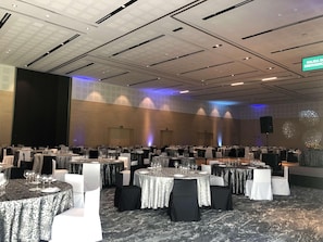 A banquet hall with round tables, white chairs, and a stage area. - Galeria Plaza San Jeronimo (Mexico City)