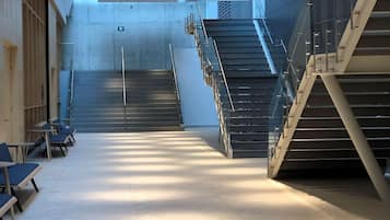 A spacious interior with a central staircase, seating area, and a skylight.