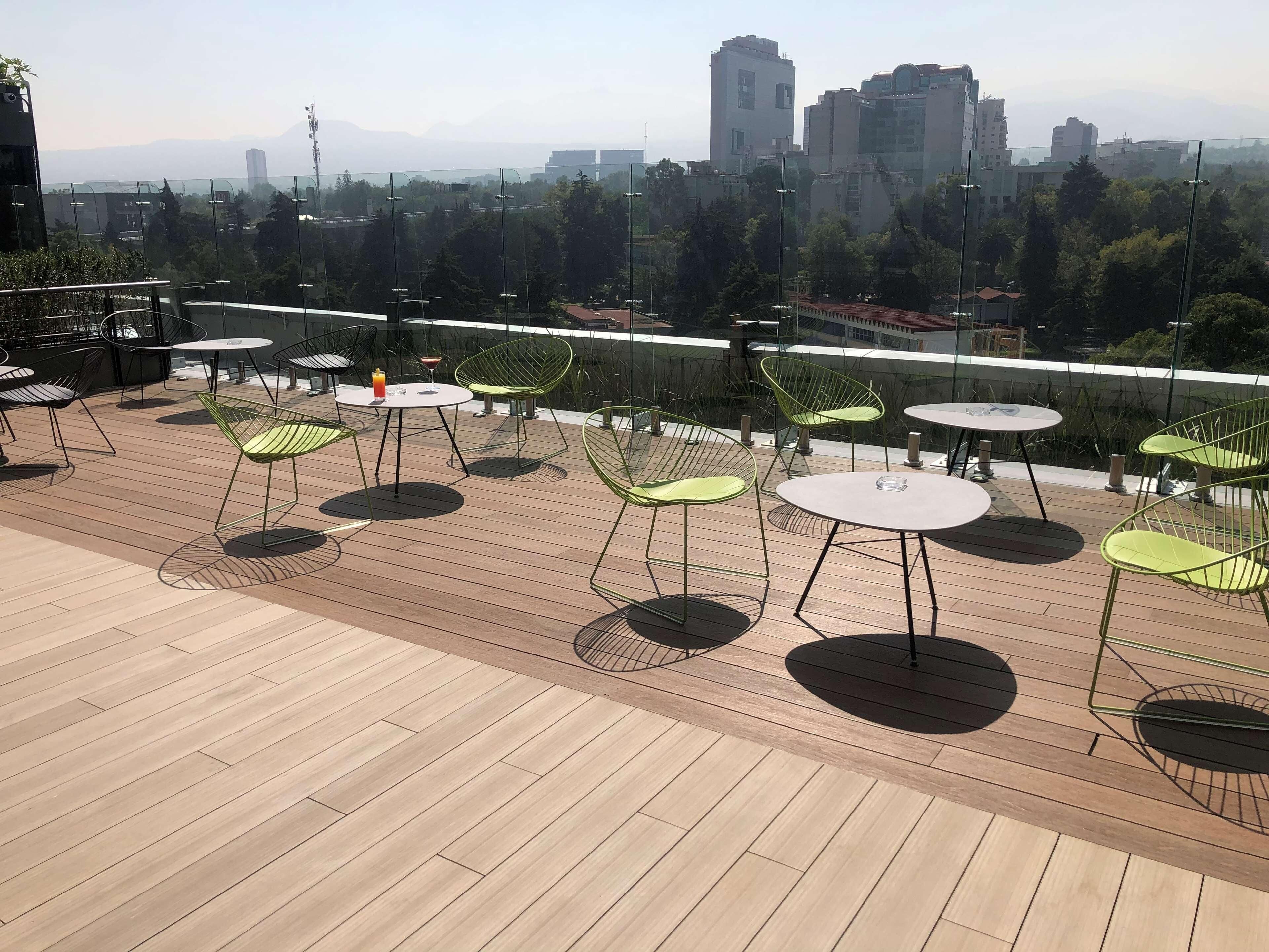Terraza en la azotea con mobiliario exterior y vistas a la ciudad.