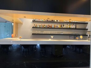A modern bar area with multiple shelves of liquor bottles and glasses. - Galeria Plaza San Jeronimo (Mexico City)
