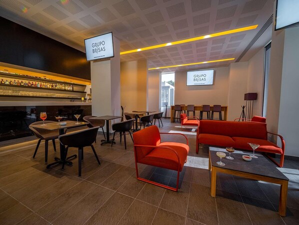 A modern lounge area with seating, a bar, and a large screen displaying "GRUPO BRIAS". - Galeria Plaza San Jeronimo (Mexico City)