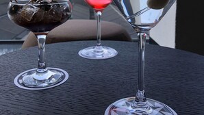 Three glasses of beverages on a table with a view of trees and buildings in the background. - Galeria Plaza San Jeronimo (Mexico City)