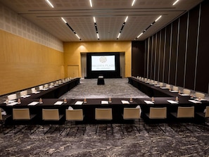 A conference room with a long table and chairs, a projector screen, and a carpeted floor. - Galeria Plaza San Jeronimo (Mexico City)