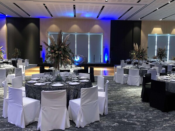 A banquet hall with round tables, white chairs, and floral centerpieces. - Galeria Plaza San Jeronimo (Mexico City)