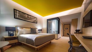 A modern hotel room with a bed, bedside tables, a desk, and a chair. - Galeria Plaza San Jeronimo (Mexico City)