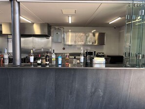 A modern kitchen with stainless steel appliances, a marble countertop, and a glass partition. - Galeria Plaza San Jeronimo (Mexico City)