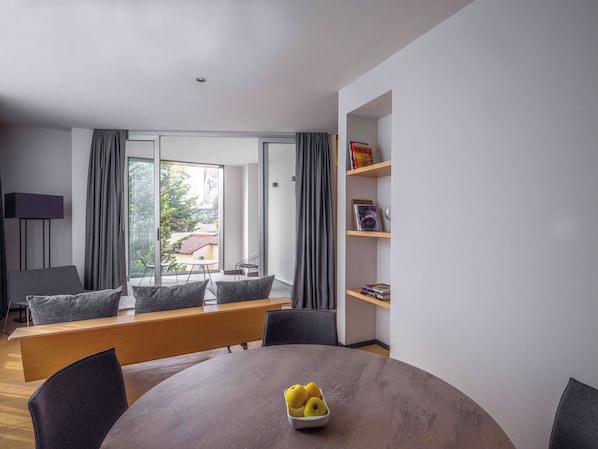 A modern living room with a round table, a bench, and a bookshelf. - Galeria Plaza San Jeronimo (Mexico City)