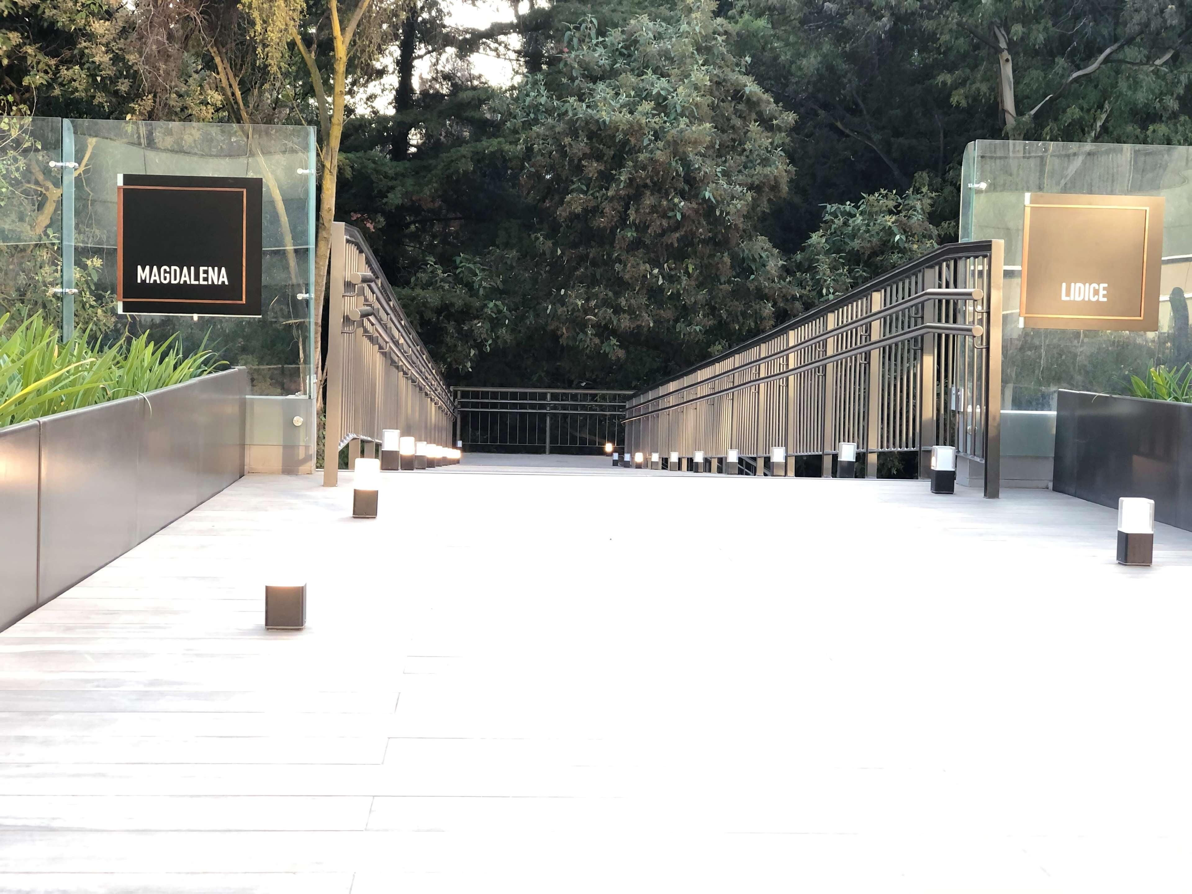 A modern building entrance with two signs reading "MAGDALENA" and "LIDICE".