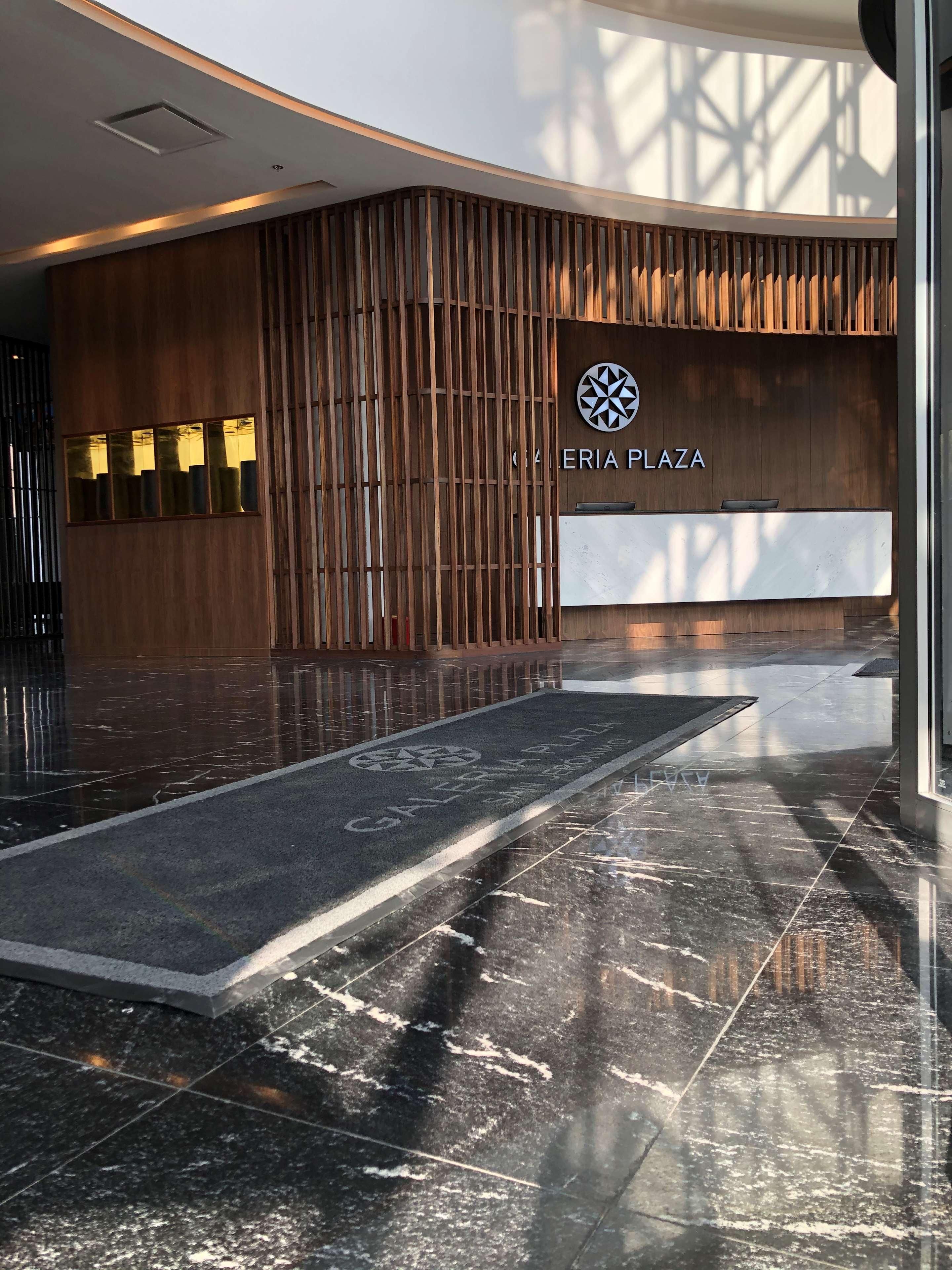 Un área de recepción moderna con paneles de madera y suelo de mármol.