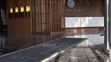 Un área de recepción moderna con paneles de madera y suelo de mármol.