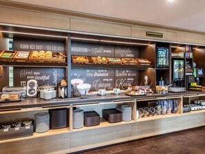 A breakfast bar with various food items and a coffee machine. - B&B Hotel Erlangen (Erlangen)