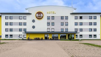 A B&B hotel with a modern design, featuring a prominent logo and a yellow facade.