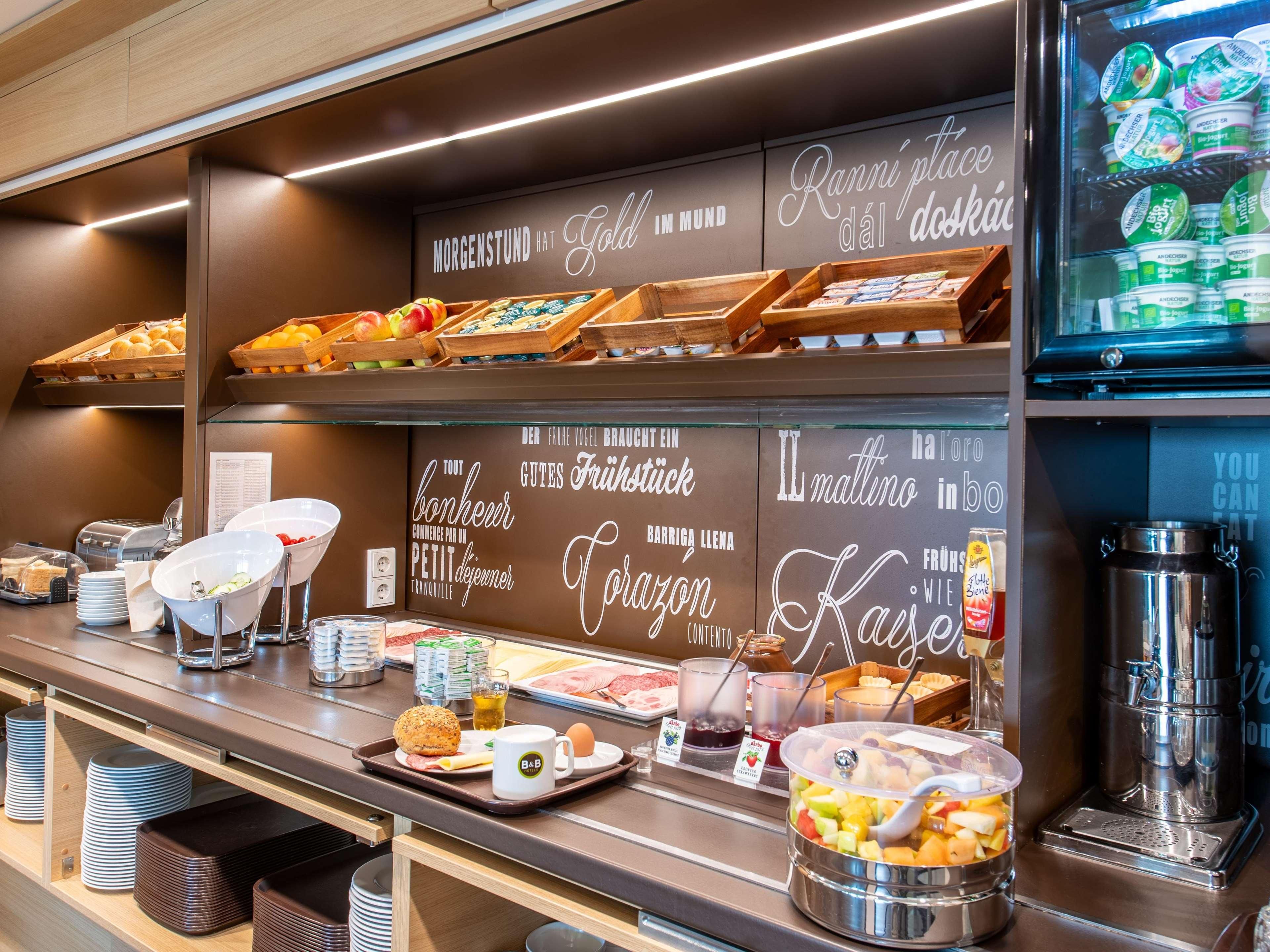 A breakfast buffet with various food items and a coffee machine.
