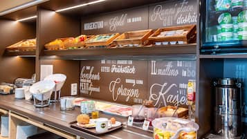 A breakfast buffet with various food items and a coffee machine.