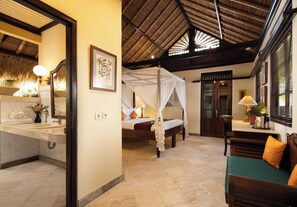 Une chambre d’hôtel comprenant un lit, un coin salon et une salle de bain.