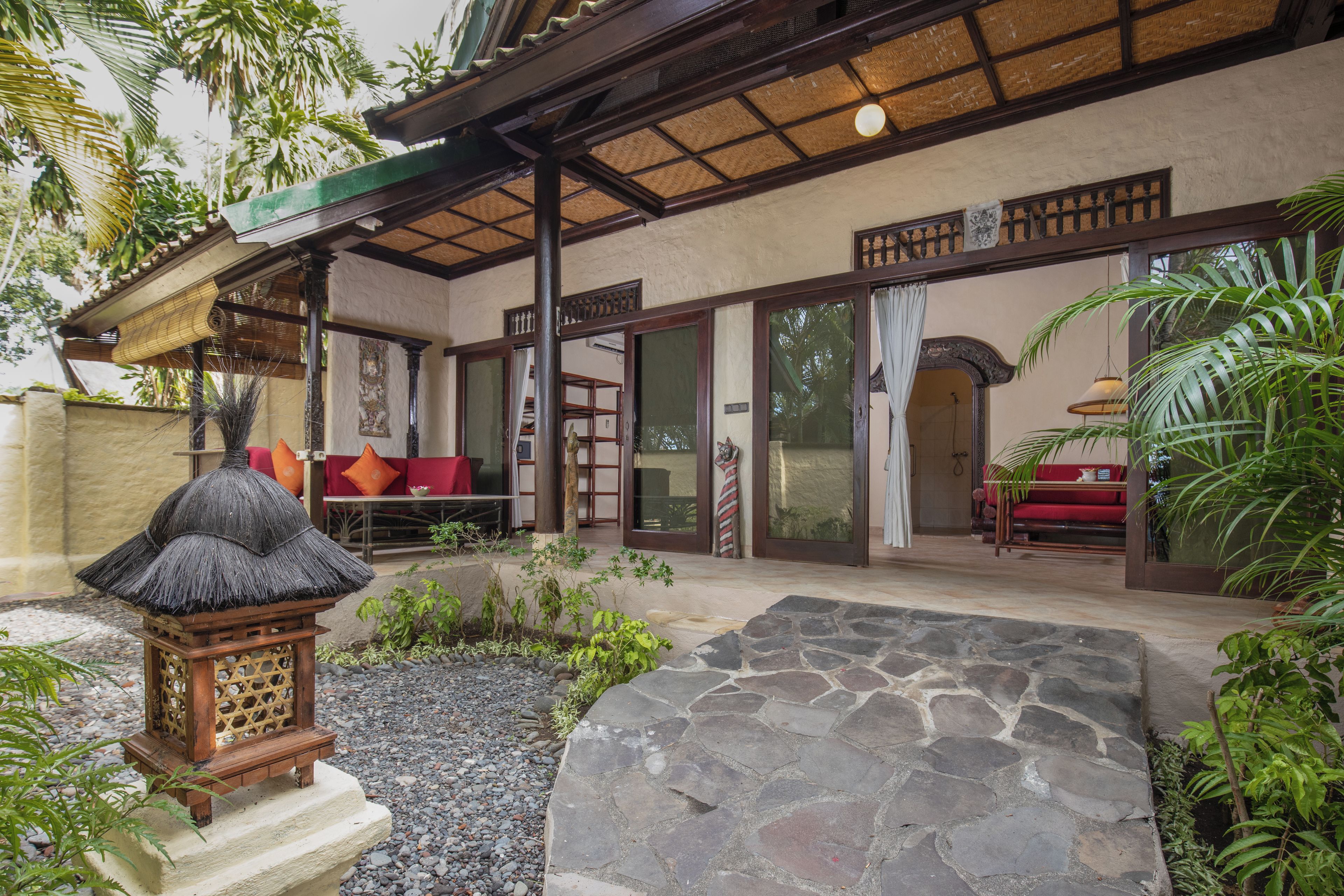 A traditional building with a covered patio, stone flooring, and a thatched lantern.