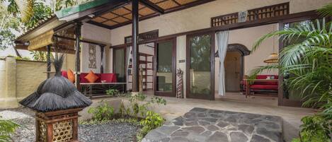 A traditional building with a covered patio, stone flooring, and a thatched lantern.