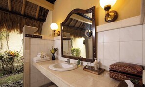Un bagno con uno specchio grande, un lavandino bianco e un porta asciugamani.
