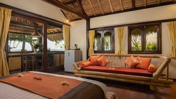 A room with a bed, a sofa, and a dining area with a table and chairs.