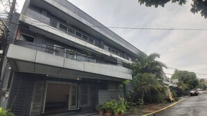 A modern two-story building with a flat roof and balconies. - OYO 881 Nest Suites (Quezon City)