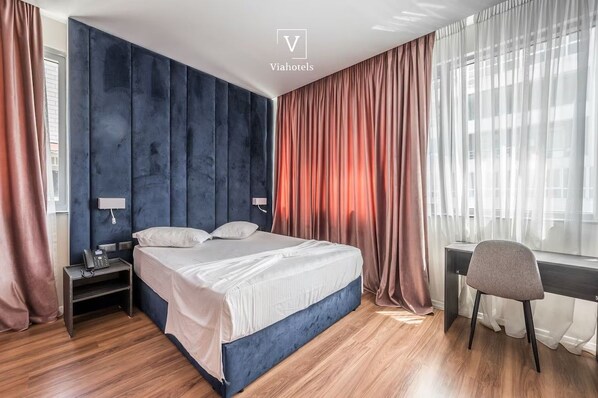 Ein modernes Schlafzimmer mit einem großen Bett, einem Schreibtisch und einem Stuhl.
