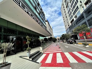 Ein modernes Hotel mit auffälliger Schilderung, einer Fußgängerampel und freiem Blick auf die Straße.