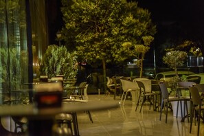 An outdoor dining area with tables and chairs, surrounded by trees and potted plants. - Vh Eurostar Tirana Hotel Congress & Spa (Tirana)