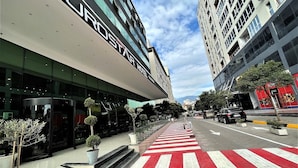 Egy modern hotel, feltűnő táblával, gyalogosátkelővel és jó kilátással az utcára.