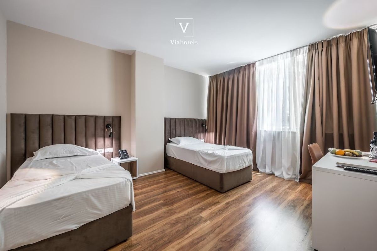 Una habitación de hotel con dos camas, un escritorio y una silla.