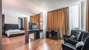 Ein modernes Hotelzimmer mit Bett, Schreibtisch und Sitzgelegenheit.