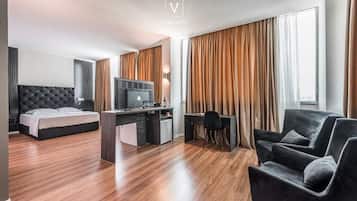 Una camera d'hotel moderna con un letto, una scrivania e un'area salotto.
