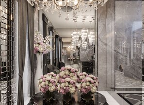 A luxurious lobby with marble flooring, elegant chandeliers, and floral arrangements. - The Plein Hotel (Milan)