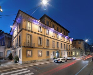 A multi-story building with a classic architectural style, featuring a balcony on the second floor and a ground-floor entrance. - The Plein Hotel (Milan)