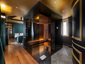 A modern hotel room with a glass-enclosed seating area, wooden flooring, and a view of the cityscape. - The Plein Hotel (Milan)