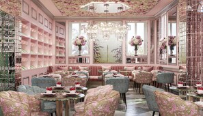 Ein luxuriöses Interieur mit einer zentralen Sitzecke, gespiegelten Wänden und floralen Dekorationen.