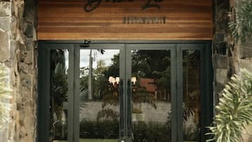 Una entrada enmarcada en piedra con un letrero de madera que dice 'Dona Le Boutique'.